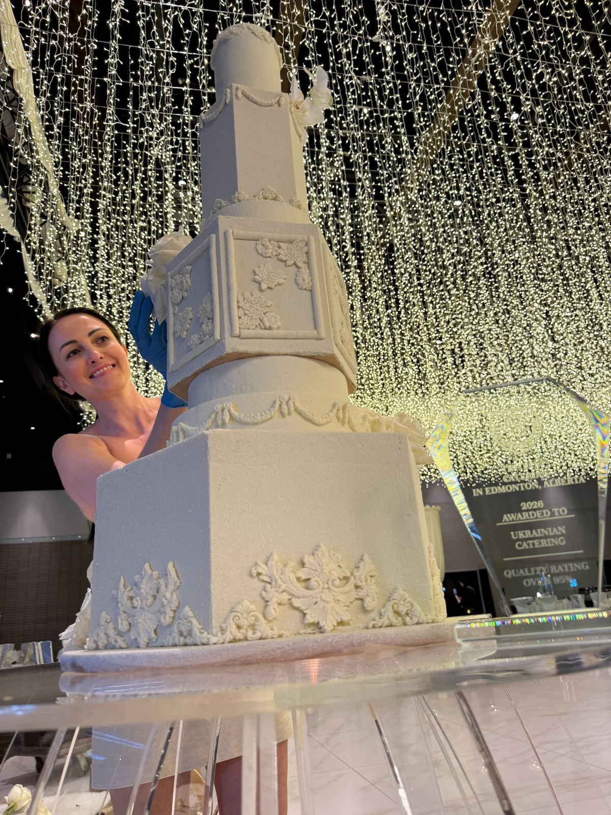 Chef Iryna beside a large custom wedding cake