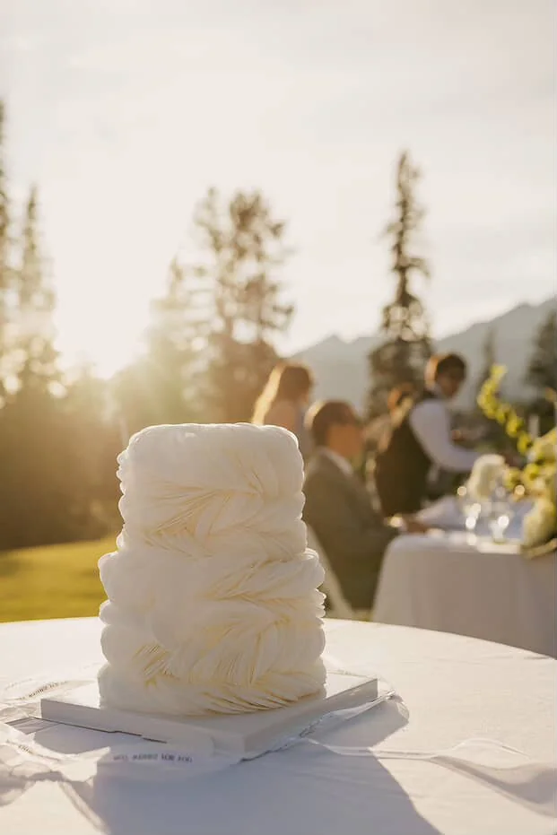 Sculptural white wedding cake at an outdoor reception